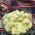 Potato salad with eggs in a glass bowl on a towel