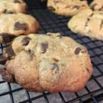 Gluten-free peanut butter chocolate chip cookies on a wire cooling rack.
