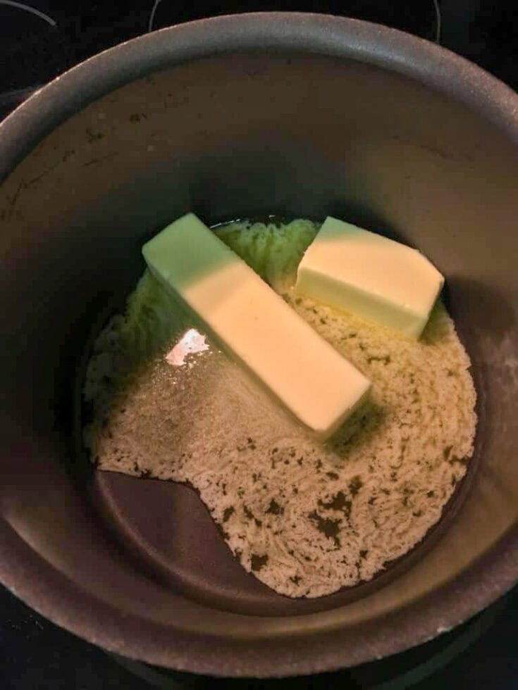 Melting one and a half sticks of butter in a dark colored saucepan.