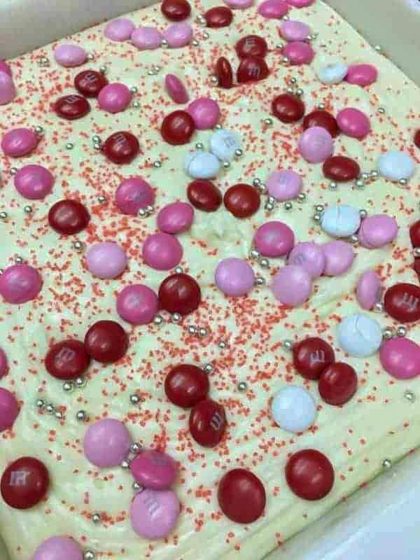 White chocolate fudge in a square pan with red, white, and pink M&Ms on top.