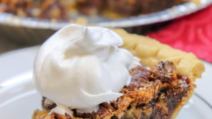 Picture of pecan pie with whipped cream on top.