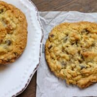 Cookies sitting on a plate and on parchment paper.
