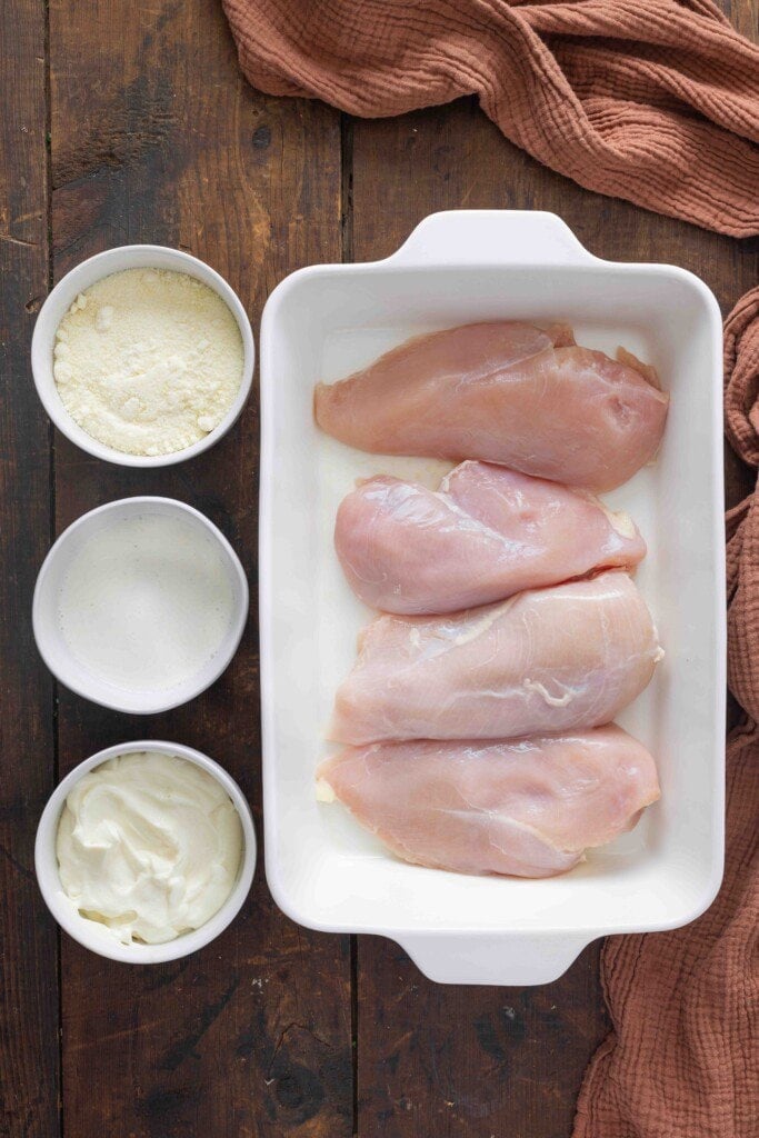 Uncooked chicken breasts in a baking dish.
