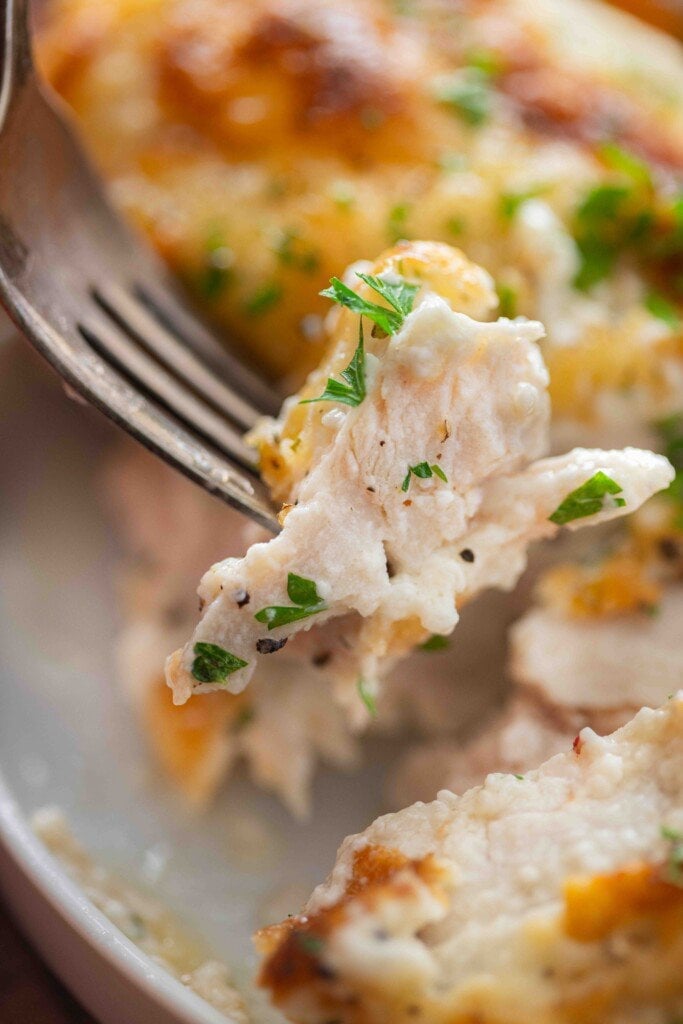 A bite of chicken on a fork.