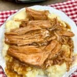 Pork chops on top of mashed potatoes with gravy