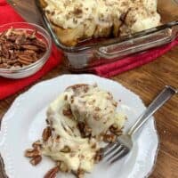 Cinnamon rolls in a dish and on a plate with pecans