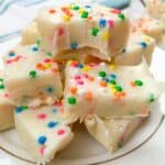 Cake batter fudge cut into pieces and stacked on a white plate
