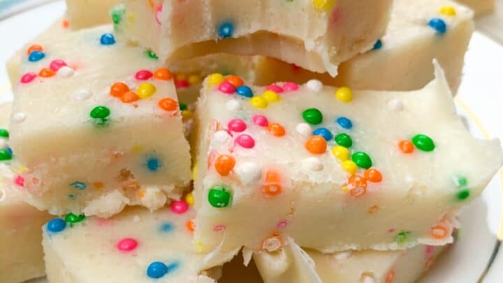 Cake batter fudge cut into pieces and stacked on a white plate