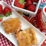 Two strawberry chess squares on a white plate