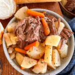 Pot roast on a plate with beef, potatoes, and carrots