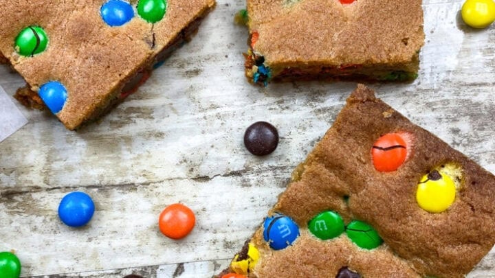 Cookie bars on a counter with M&Ms scattered.
