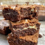 Cream cheese swirl brownies stacked on top of each other.