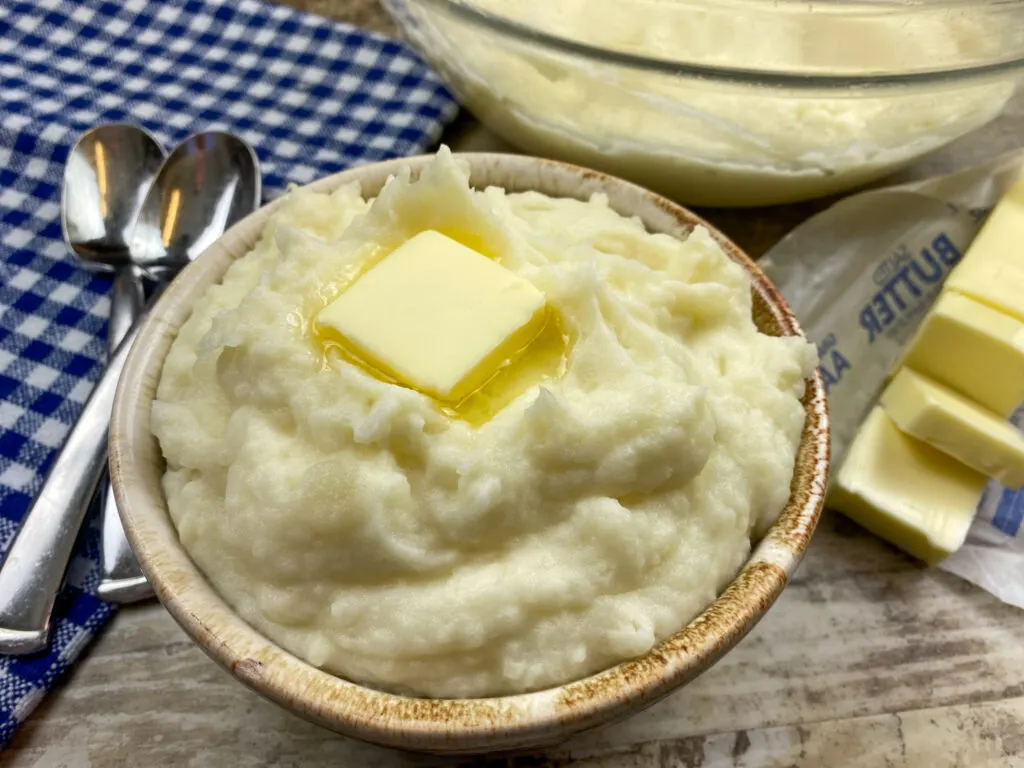 Fluffy mashed potatoes with butter in a small bowl.