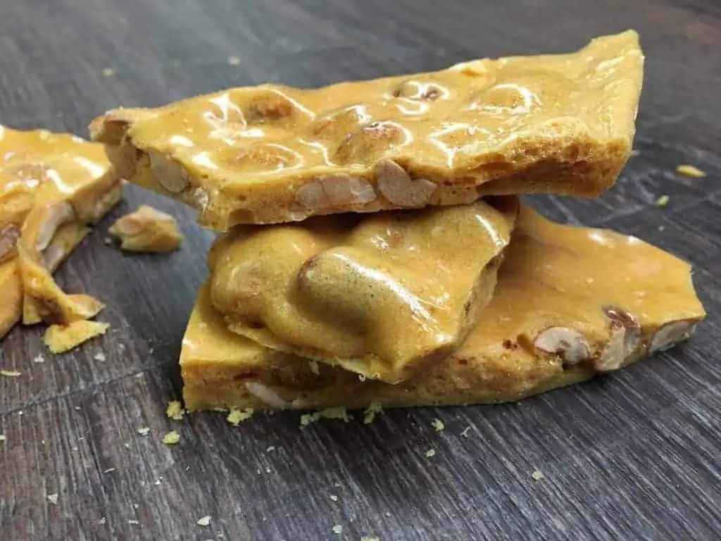 Three pieces of peanut brittle stacked on top of each other.