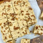 Butter pecan fudge cut into pieces on parchment paper.