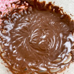 Chocolate icing in a glass bowl.