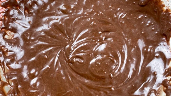 Chocolate icing in a glass bowl.