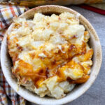 Cheesy potato casserole in a small bowl.