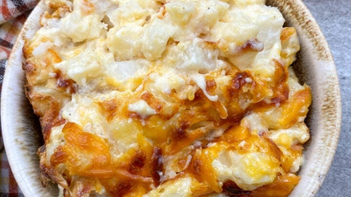 Cheesy potato casserole in a small bowl.
