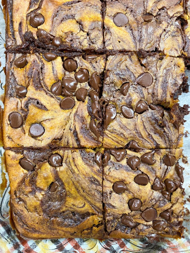 Cream cheese swirl brownies with pumpkin in a glass dish.