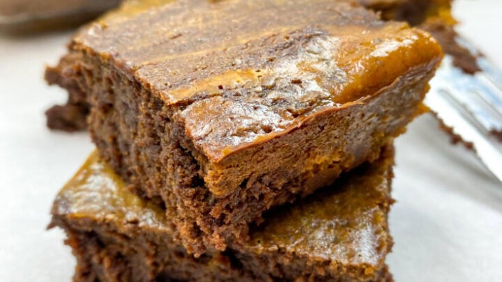 Pumpkin brownies stacked oh top of each other.