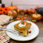 A slice of pumpkin cheesecake dessert on a white plate.