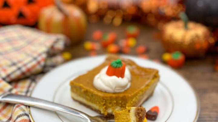 A slice of pumpkin cheesecake dessert on a white plate.