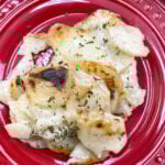 Easy homemade scalloped potatoes on a red plate.