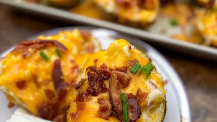 Twice baked potato on a plate with sour cream.