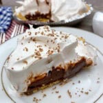 A slice of chocolate cream pie on a white plate.