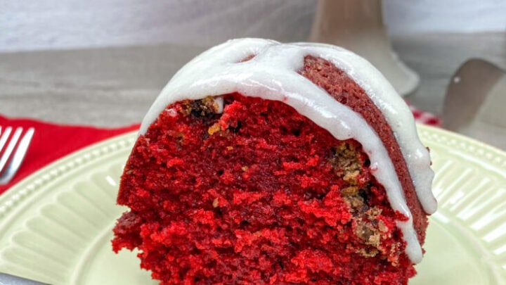 A slice of red velvet bundt cake with cream cheese frosting on a plate.