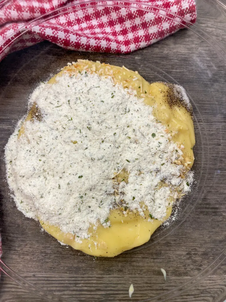 Dry ranch dressing on top of soup in a glass bowl.
