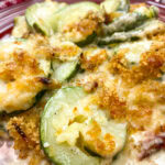 Baked zucchini casserole on a red plate.