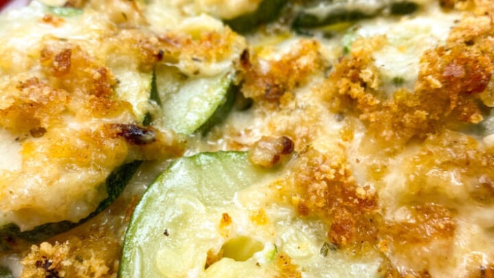 Baked zucchini casserole on a red plate.