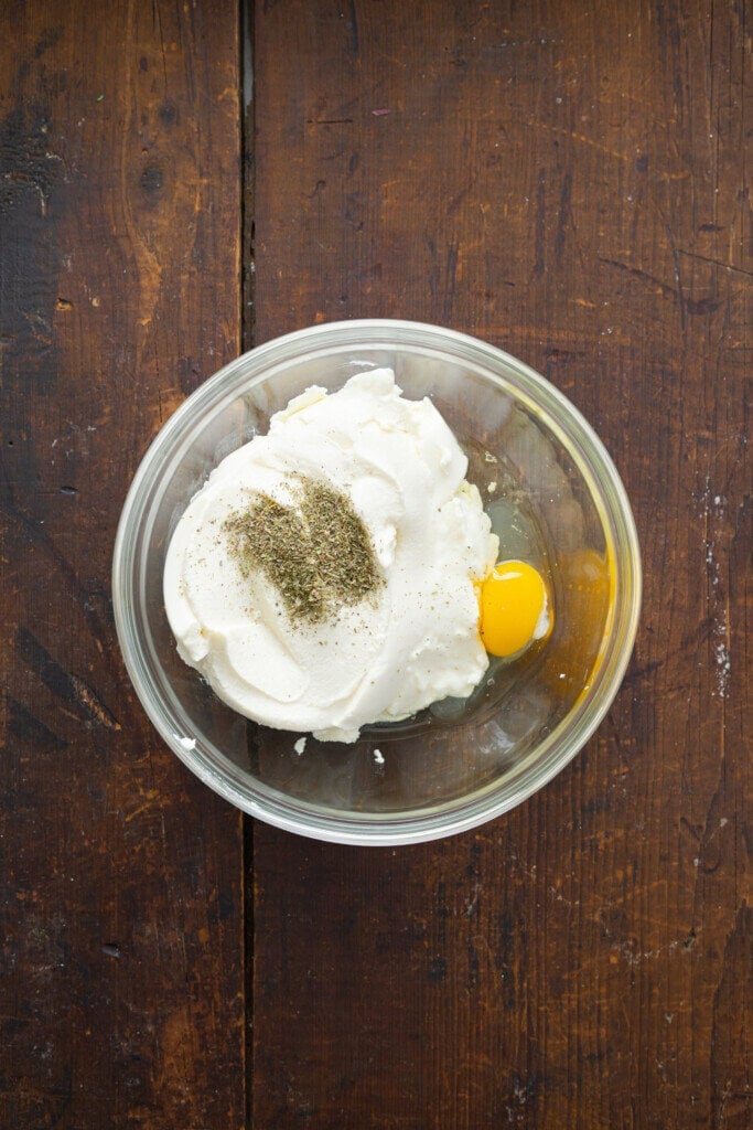 Egg and ricotta cheese in a mixing bowl.