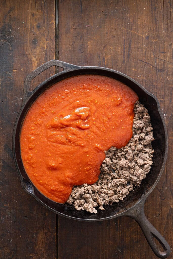 Ground beef and spaghetti sauce in a skillet.