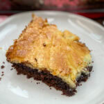 A chocolate chess cake square on a white plate.