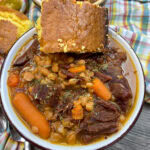 Beans and ham in a bowl with cornbread.
