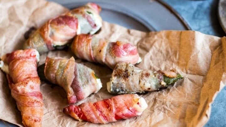 Jalapeno poppers on a plate with bacon