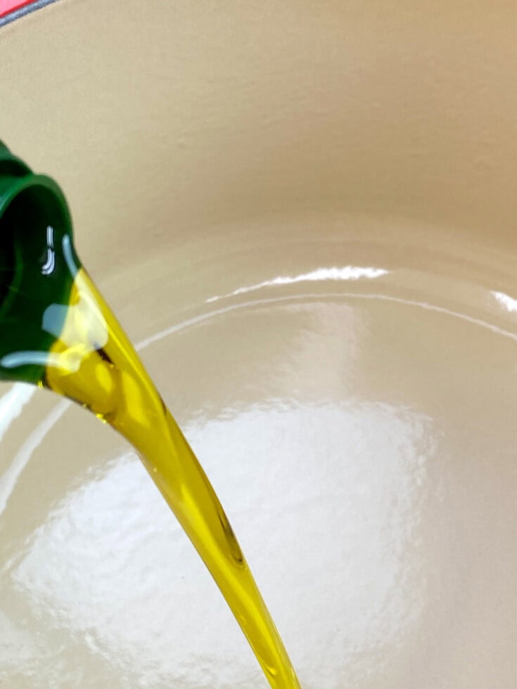 Pouring olive oil into a dutch oven