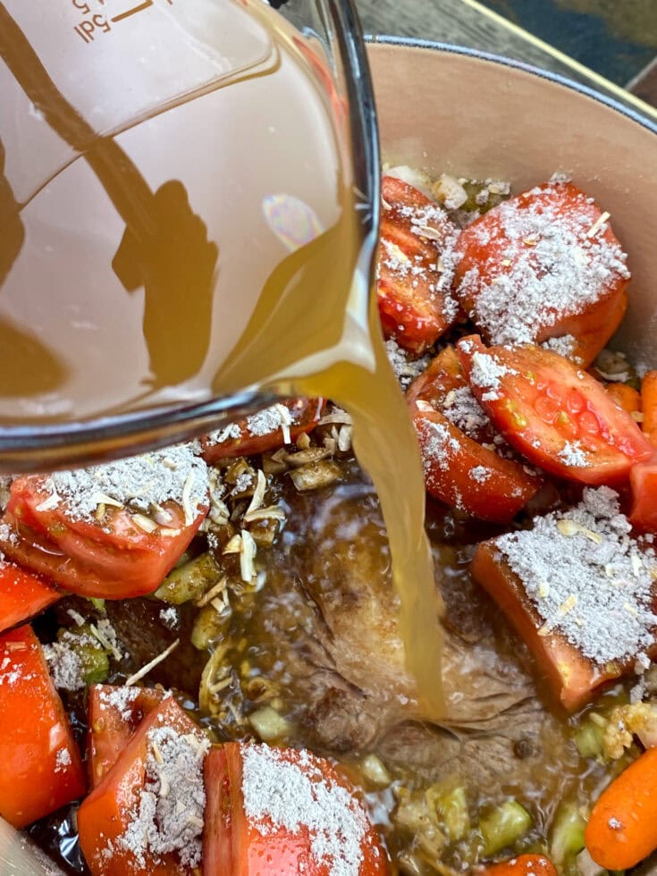 Pouring beef broth into the pan.