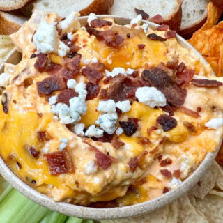 Chicken dip in a bowl with bleu cheese on top