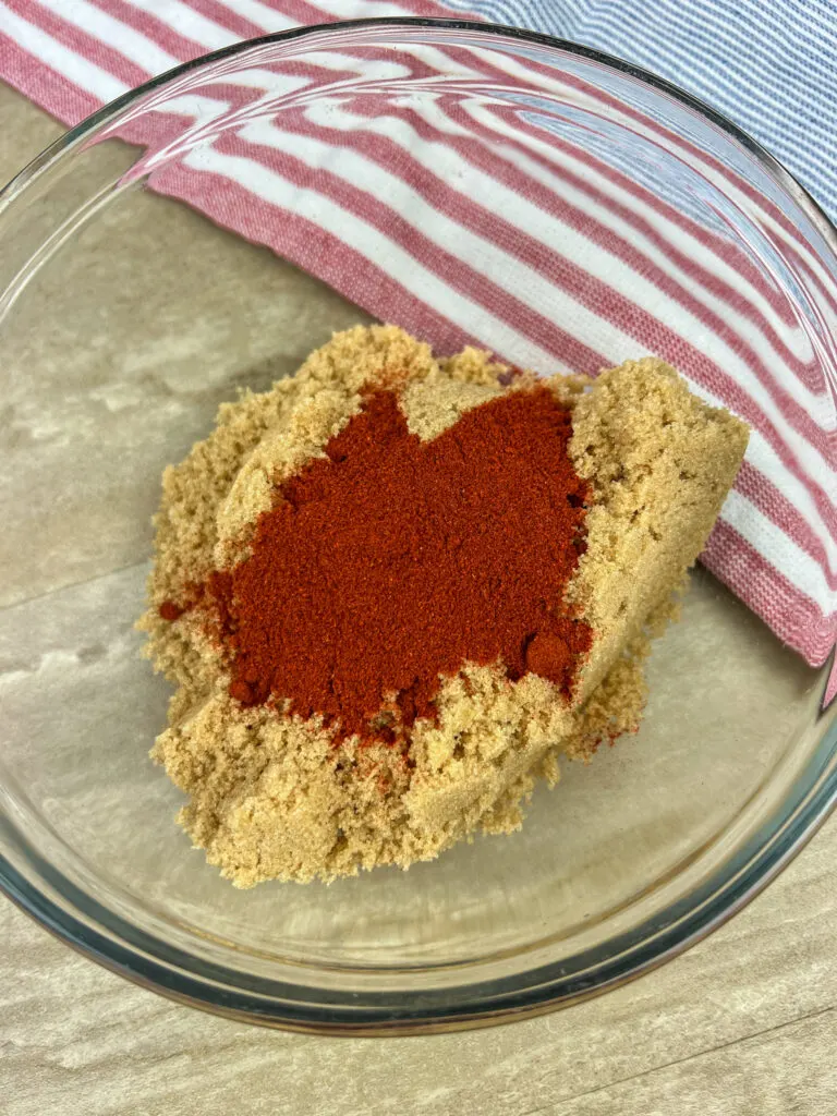 Brown sugar and smoked paprika in a small clear glass bowl.
