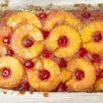 Pineapple upside down cake on a wooden cutting board.