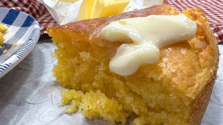 A slice of cornbread with melted butter sliding off the top.