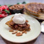 Brown butter pecan pie with whipped cream on a beige plate.