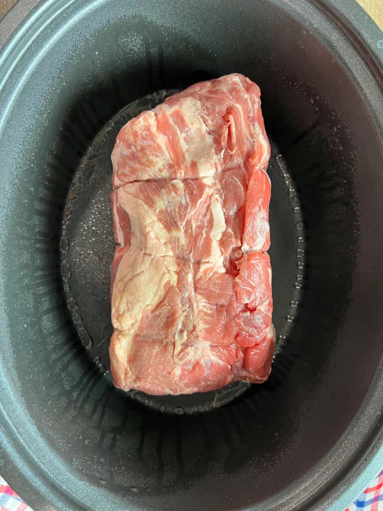 Pork butt in a slow cooker.