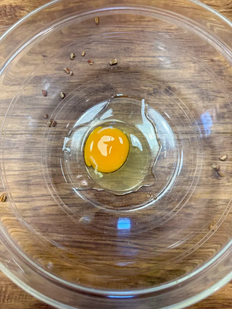 One egg in a large glass mixing bowl.