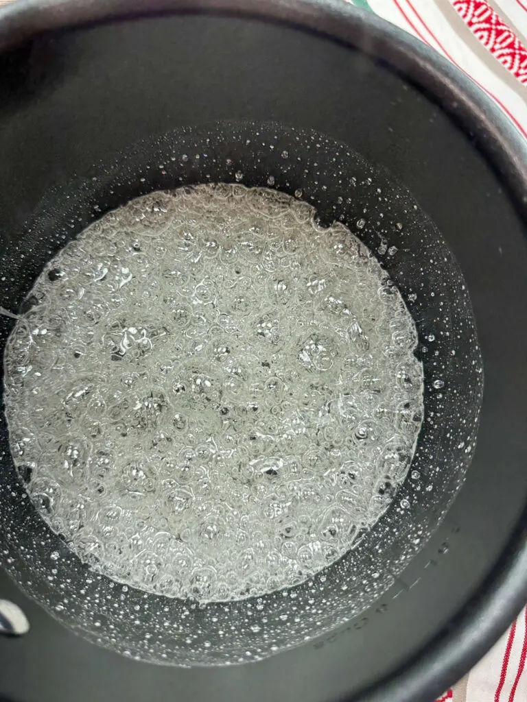 Boiling the sugar and corn syrup in a black saucepan.