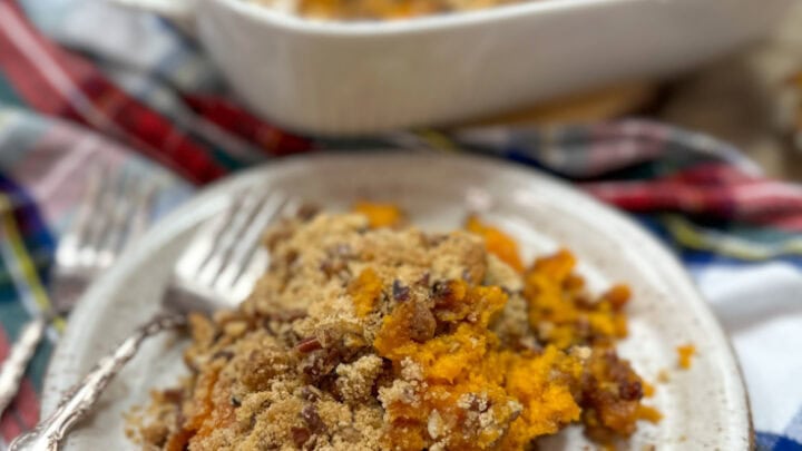 Copycat Ruth Chris sweet potato casserole on a plate. The casserole dish is in the background.